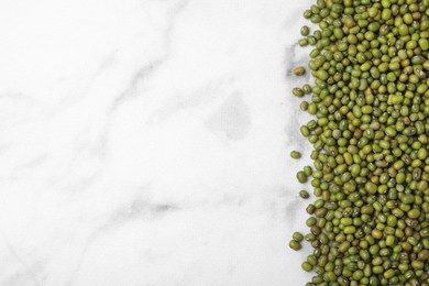 Photo of Green mung beans on white marble table, top view. Space for text