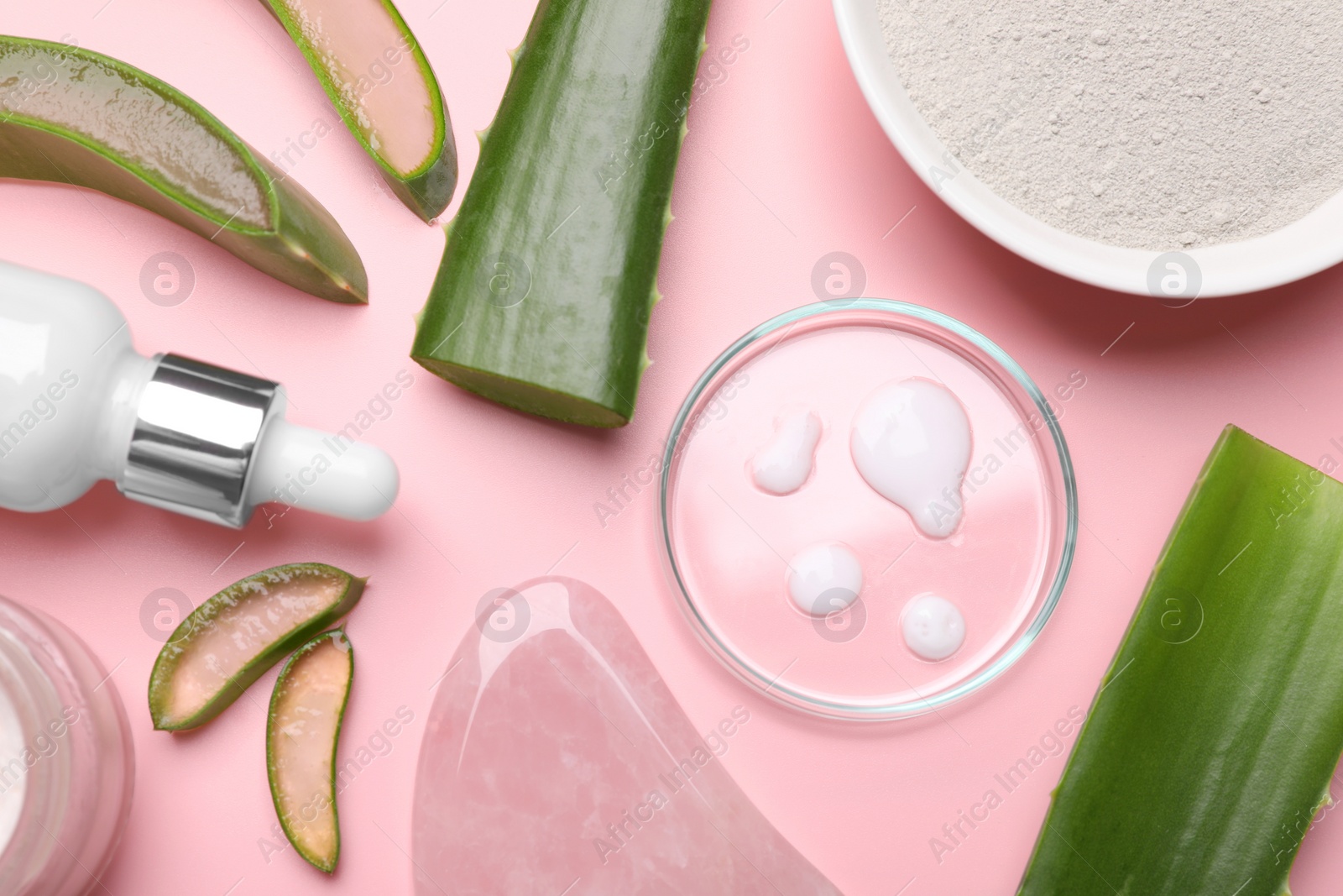 Photo of Flat lay composition with cosmetic products and cut aloe leaves on pink background