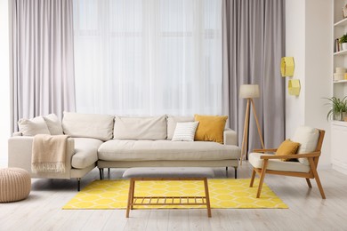 Photo of Spring atmosphere. Stylish room interior with comfy sofa, lamp, ottoman and armchair
