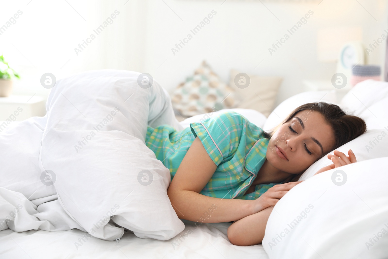 Photo of Portrait of beautiful young woman sleeping in large bed