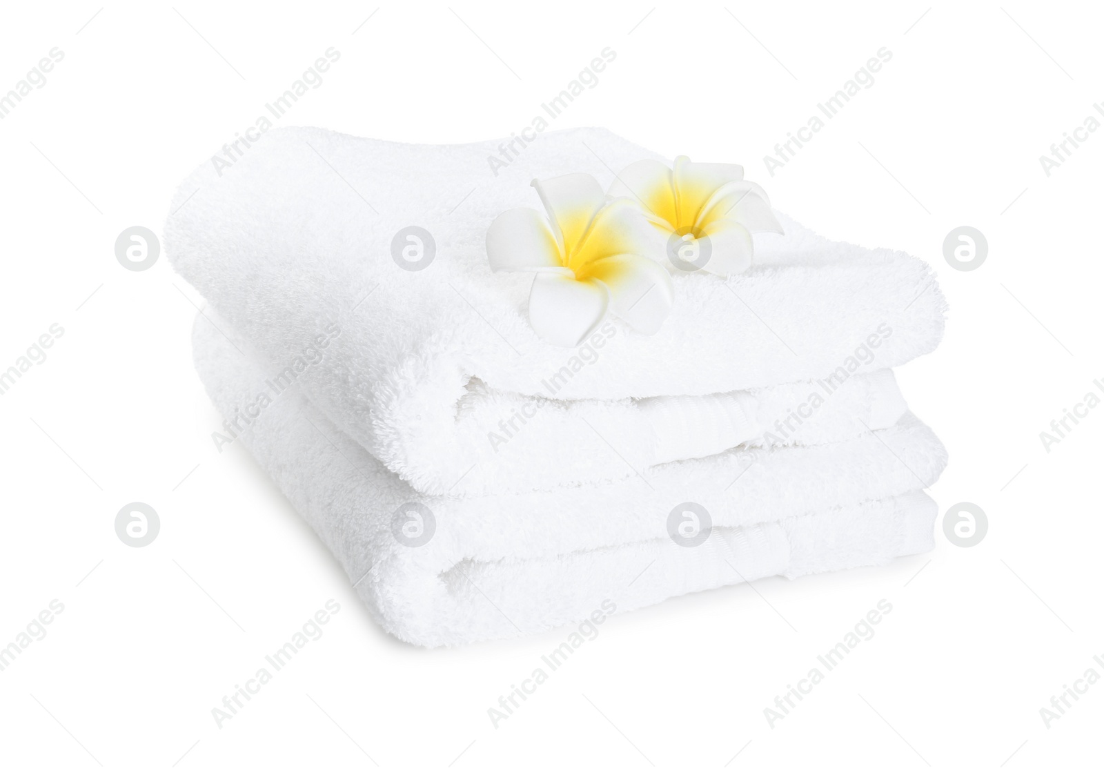 Photo of Terry towels and plumeria flowers isolated on white