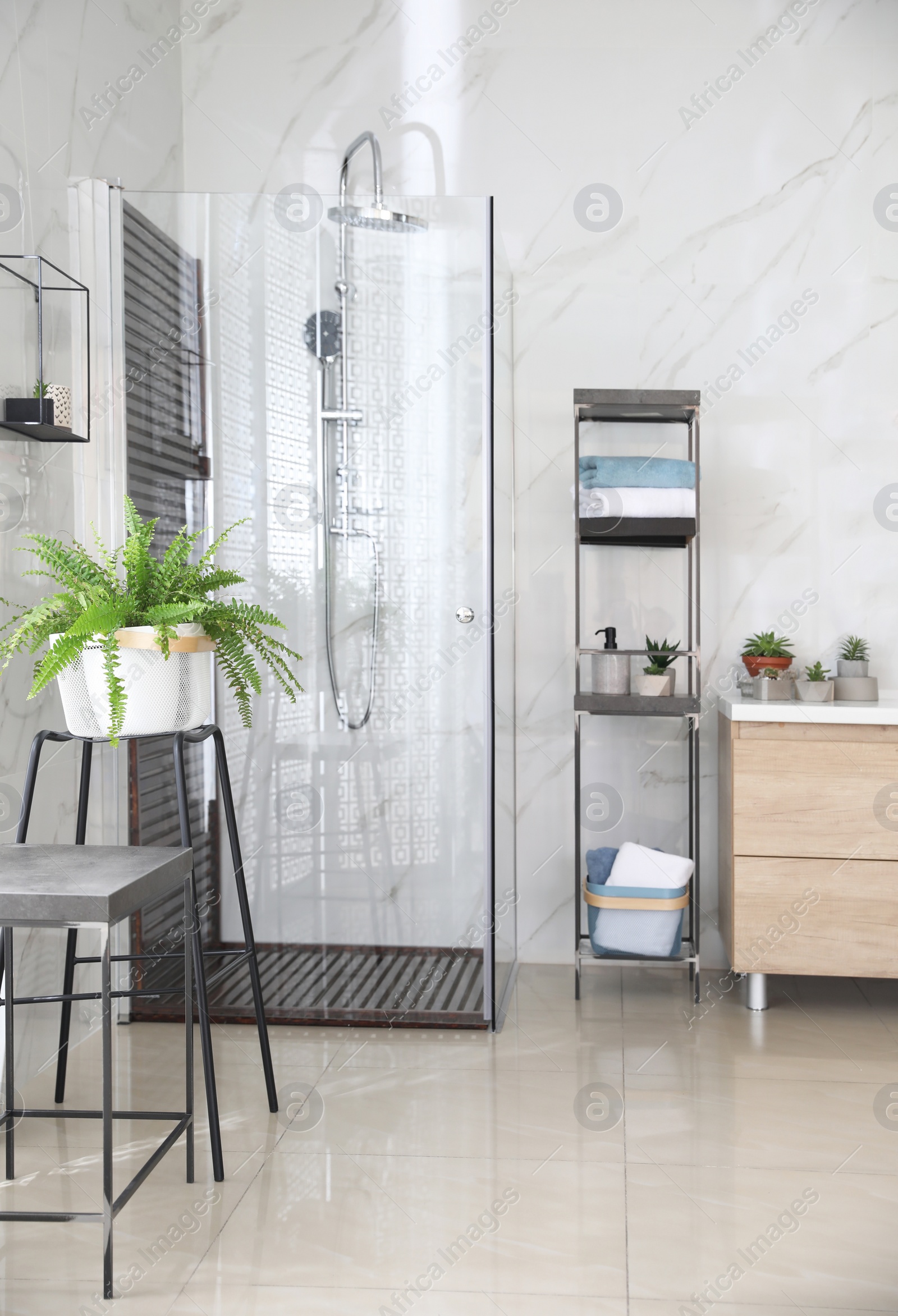 Photo of Bathroom interior with shower stall and shelving unit. Idea for design