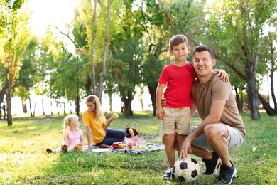 Photo of Happy family having picnic in park on sunny day