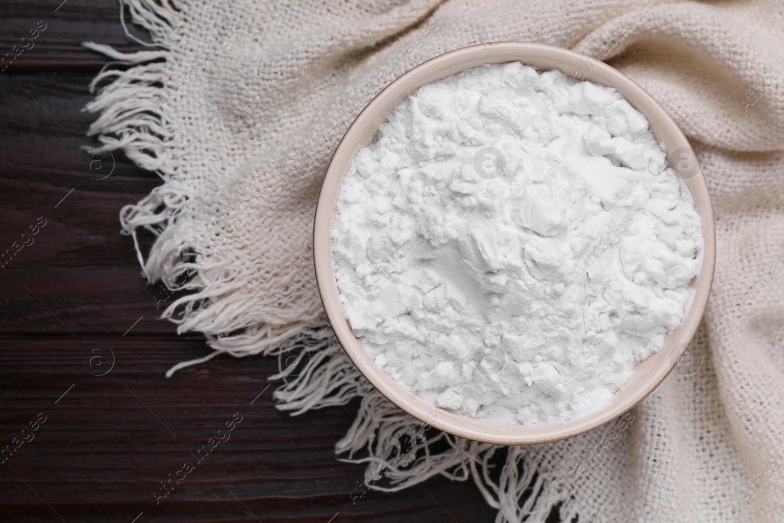 Photo of Starch in bowl on wooden table, top view