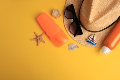 Photo of Flat lay composition with bottles of sunscreen on yellow background. Space for text