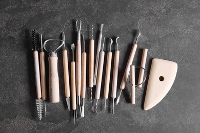 Set of different clay crafting tools on grey table, top view