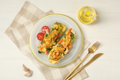 Photo of Flat lay composition with baked stuffed zucchinis served on white wooden table