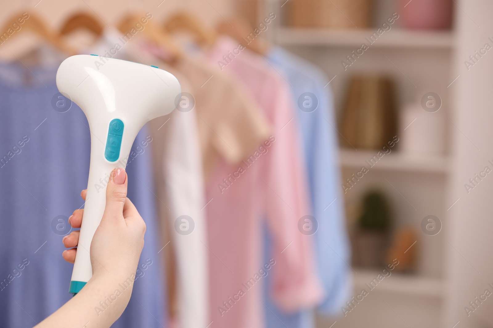 Photo of Woman with modern steam iron at home, closeup. Space for text