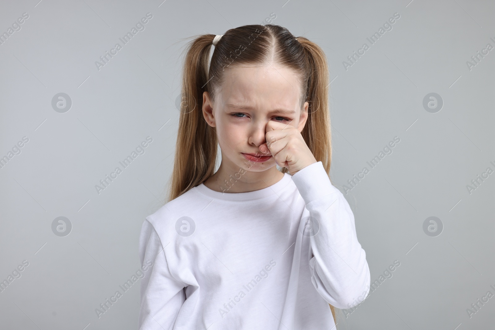 Photo of Portrait of sad girl on light grey background