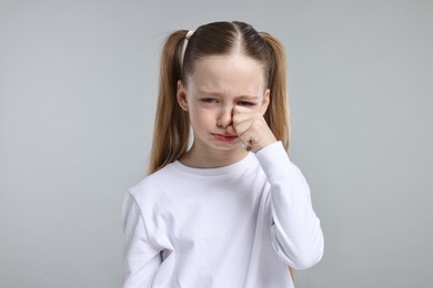 Portrait of sad girl on light grey background