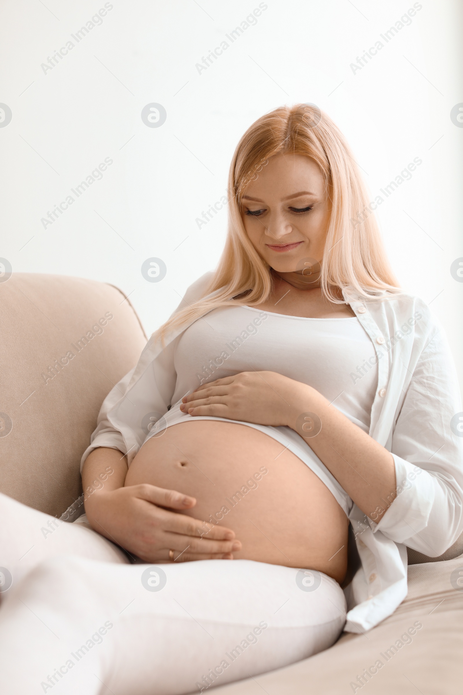 Photo of Beautiful pregnant woman resting on sofa at home