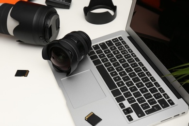 Photo of Laptop and professional photographer's equipment on table