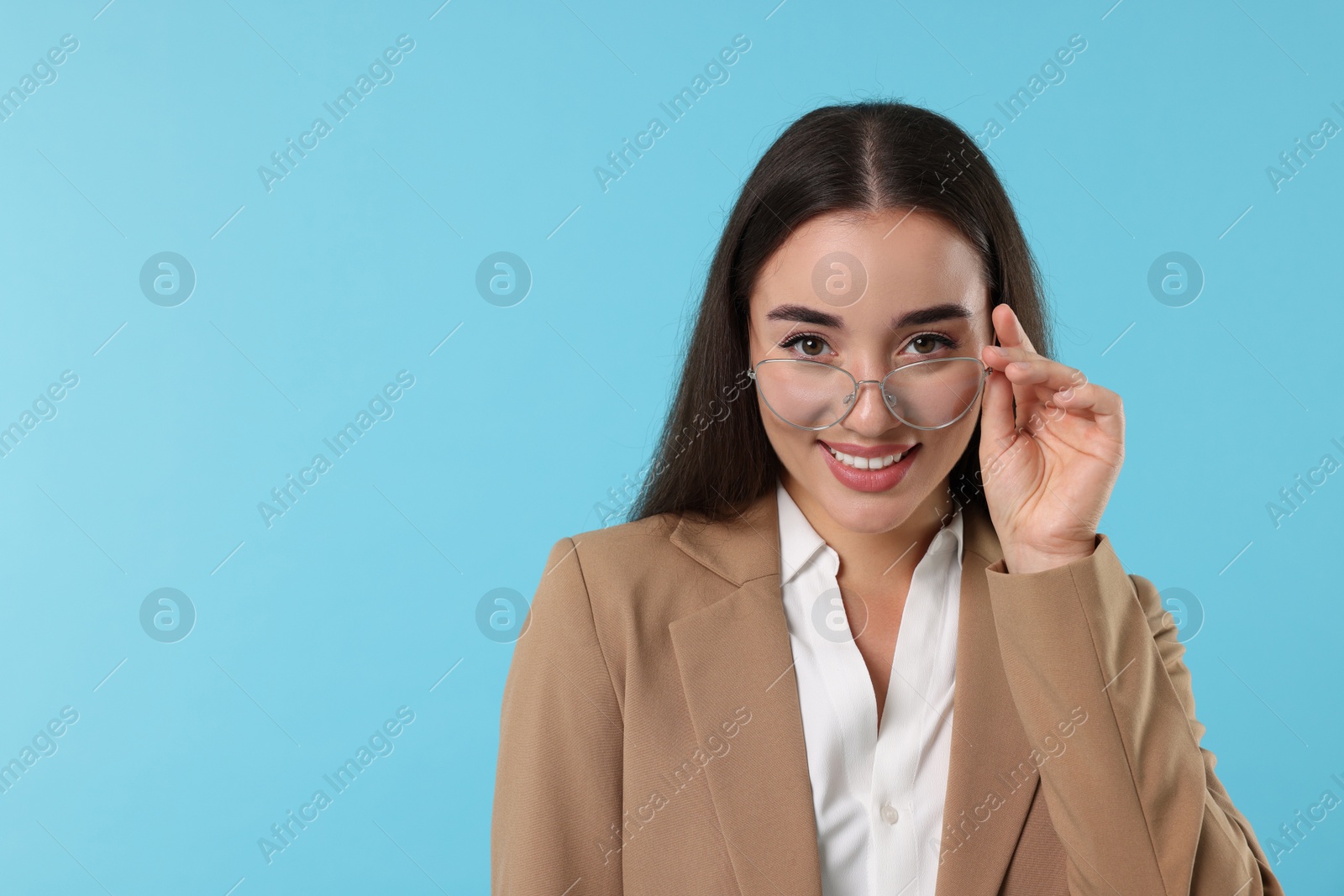 Photo of Beautiful woman wearing glasses on turquoise background, space for text