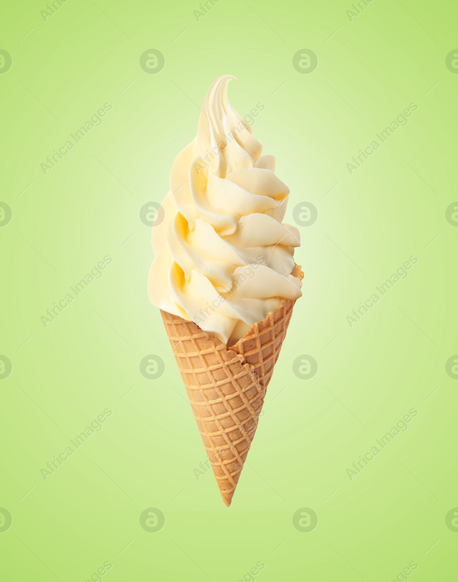 Image of Delicious soft serve vanilla ice cream in crispy cone on pastel green background