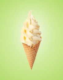 Delicious soft serve vanilla ice cream in crispy cone on pastel green background
