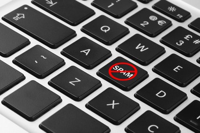 Image of Prohibition sign with word Spam on laptop button, closeup. Device keyboard