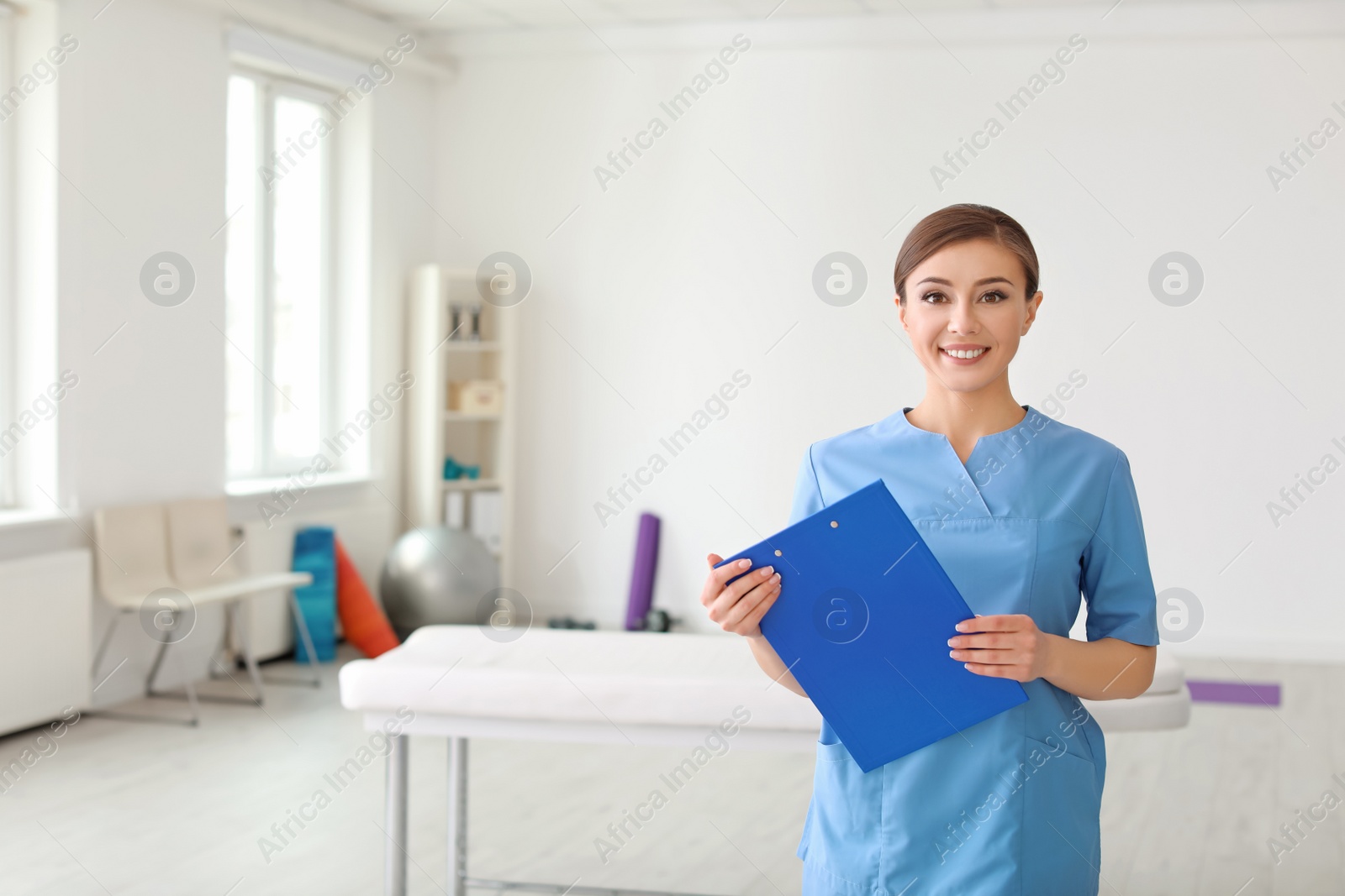 Photo of Young physiotherapist with clipboard in rehabilitation center