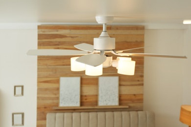 Photo of Modern ceiling fan with lamps indoors. Interior element