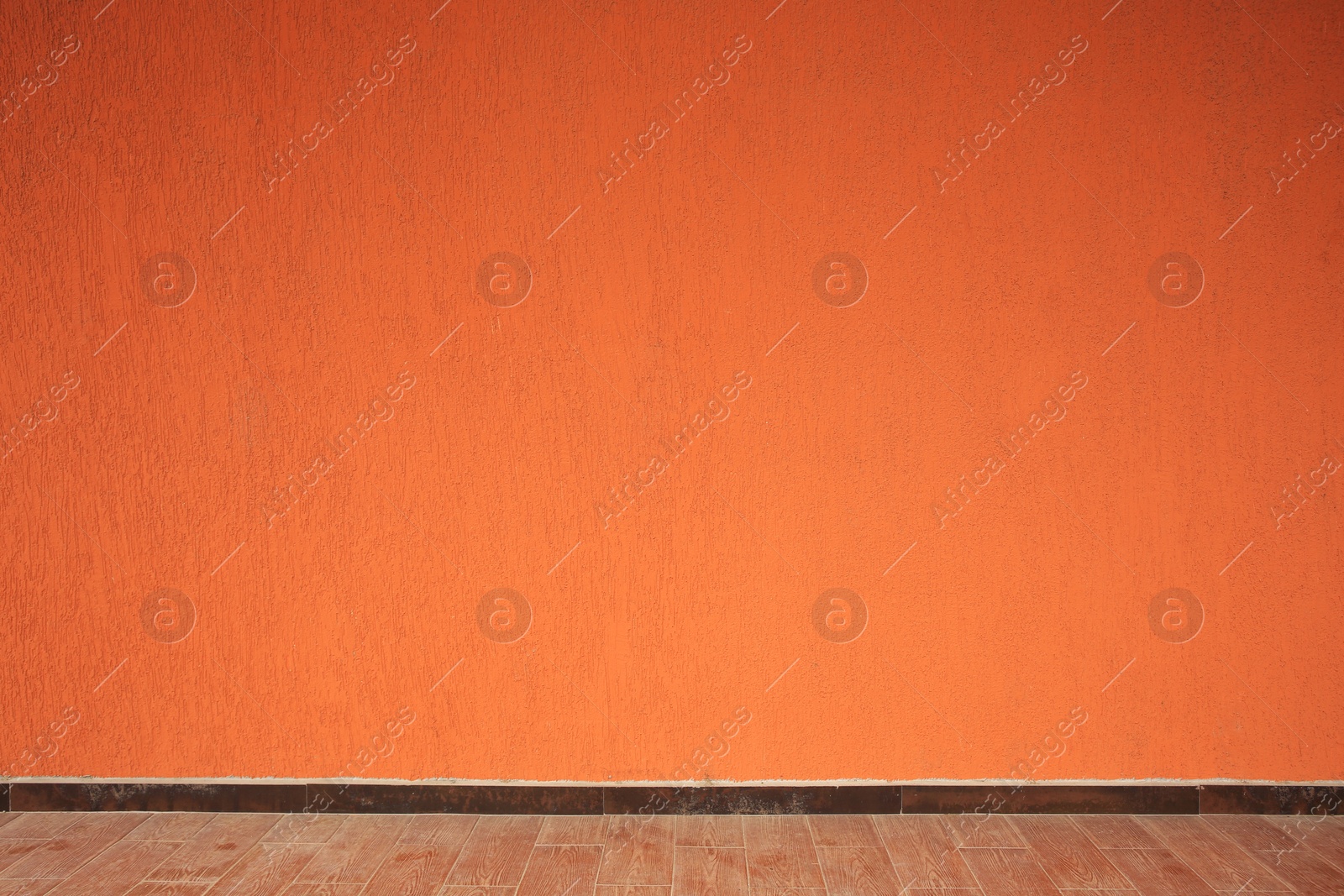 Photo of Beautiful orange wall and wooden floor made of planks