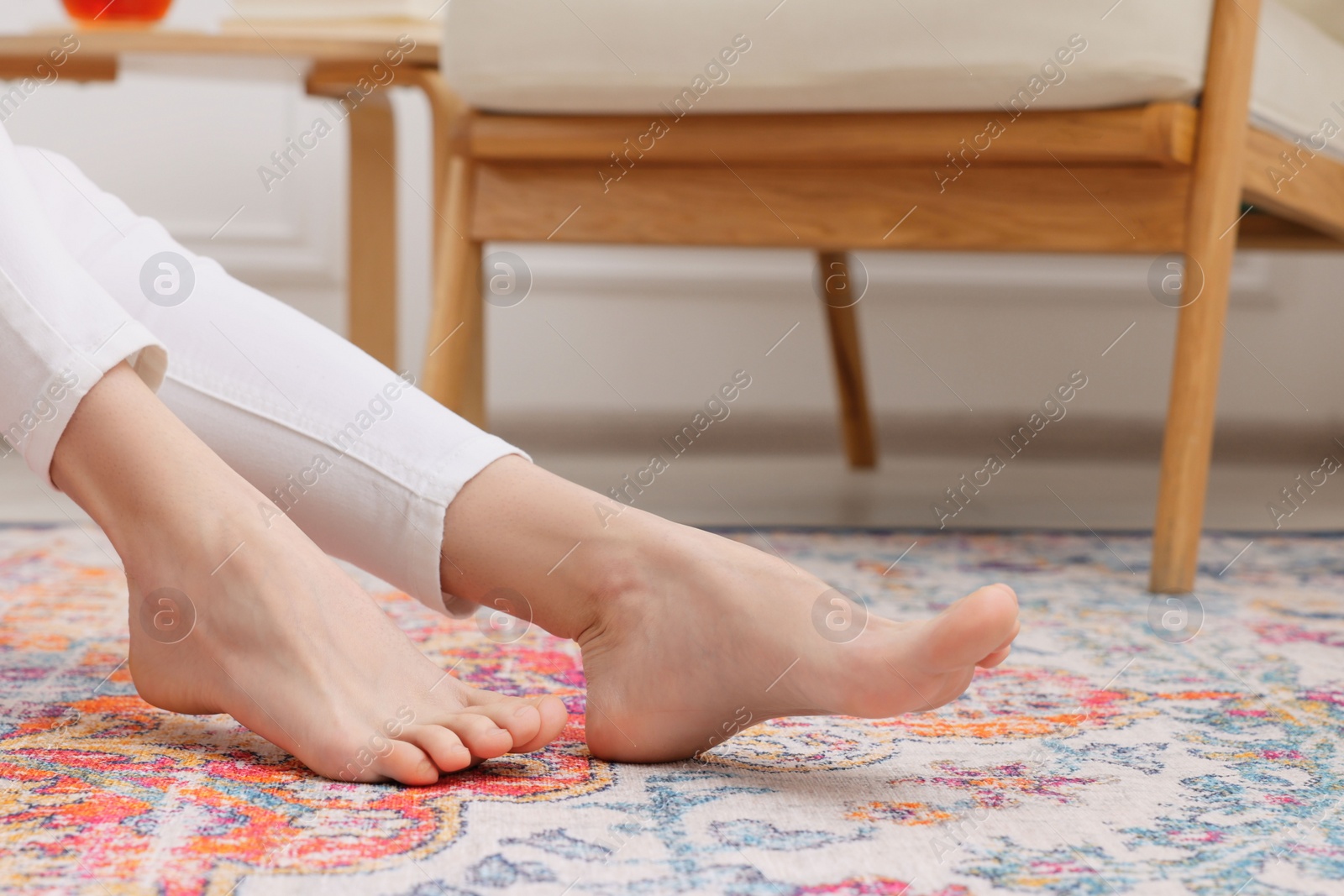 Photo of Woman on carpet with pattern at home, closeup. Space for text