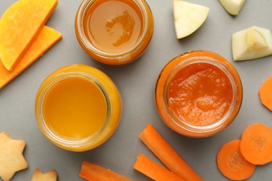 Jars with healthy baby food, vegetables and apple on grey background , flat lay