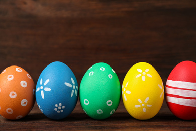 Photo of Colorful Easter eggs on wooden background. Space for text