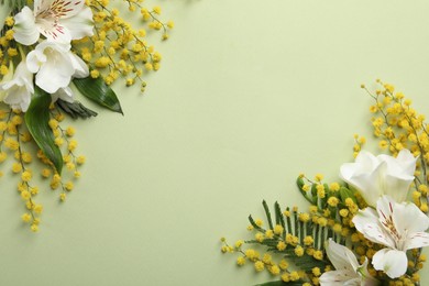 Photo of Beautiful floral composition with mimosa flowers on green background, flat lay. Space for text