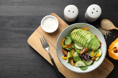 Photo of Healthy dish high in vegetable fats served on black wooden table, flat lay. Space for text