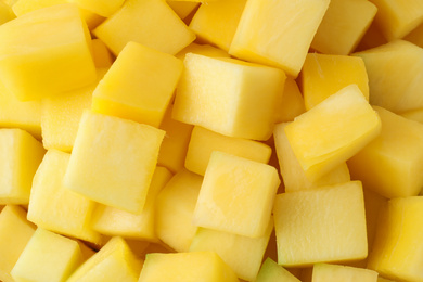 Photo of Many delicious mango cubes as background, closeup