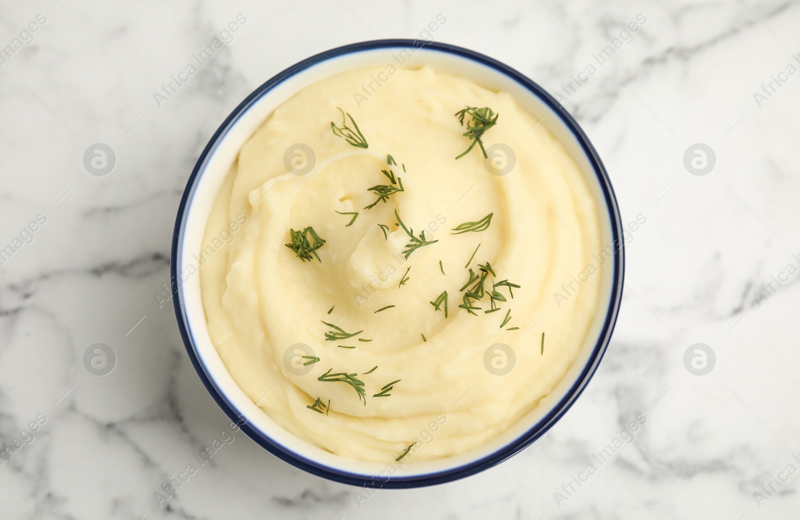 Photo of Freshly cooked homemade mashed potatoes on white marble table, top view