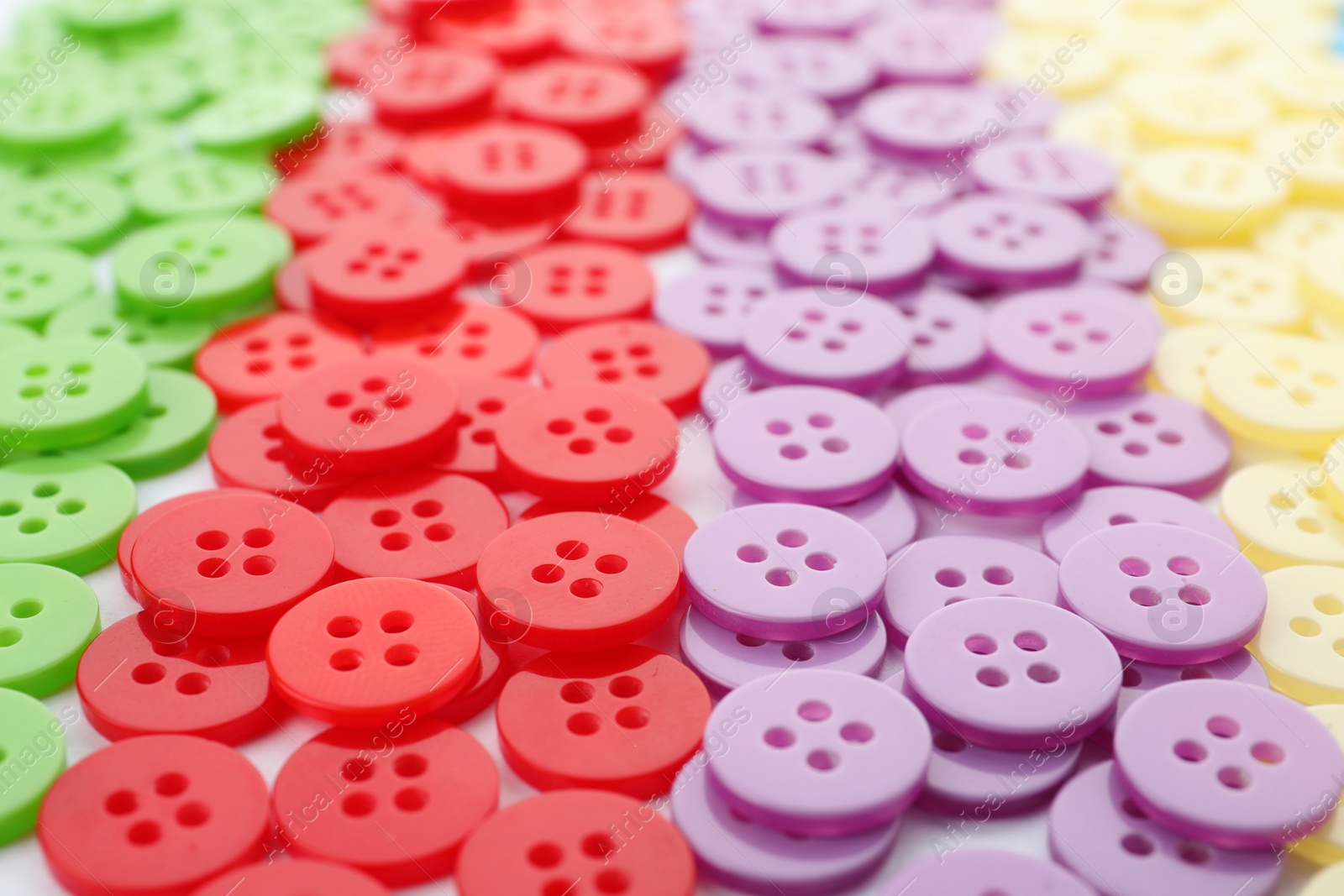 Photo of Many colorful plastic sewing buttons as background, closeup