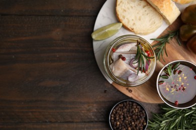 Tasty marinated fish with onion and rosemary in jar on wooden table, flat lay. Space for text