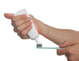 Photo of Man applying toothpaste on brush against white background, closeup