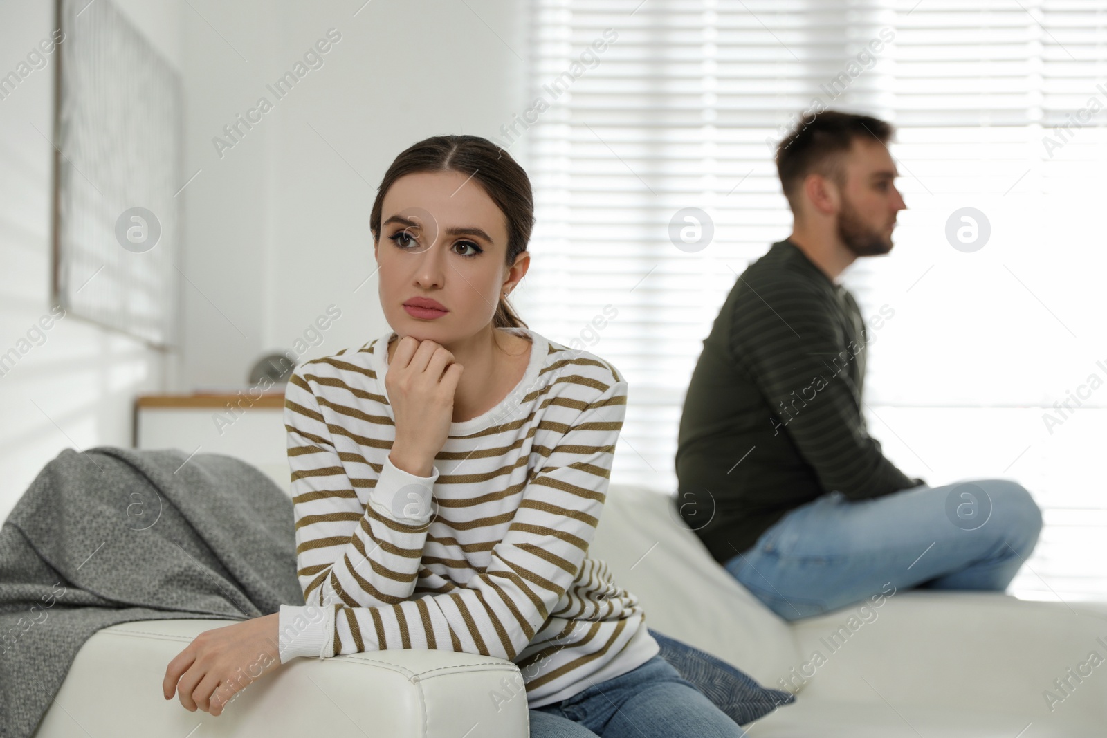 Photo of Young couple quarreling at home. Jealousy in relationship