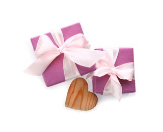 Beautiful gift boxes and wooden heart on white background, top view. Valentine's Day celebration