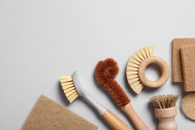 Photo of Cleaning brushes and sponges on grey background, flat lay. Space for text