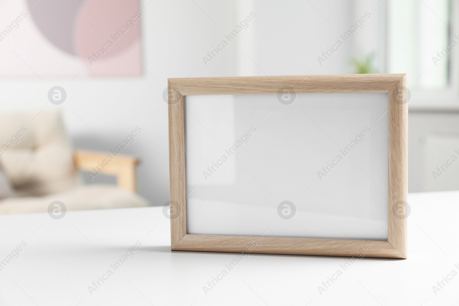 Photo of Blank board on white table in living room. Space for text