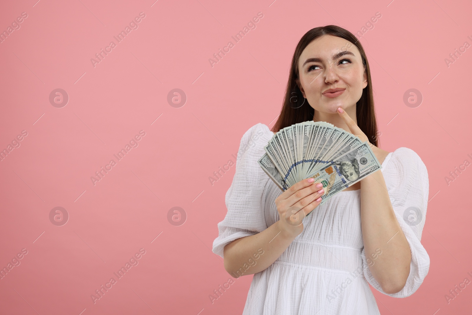 Photo of Woman with dollar banknotes on pink background, space for text