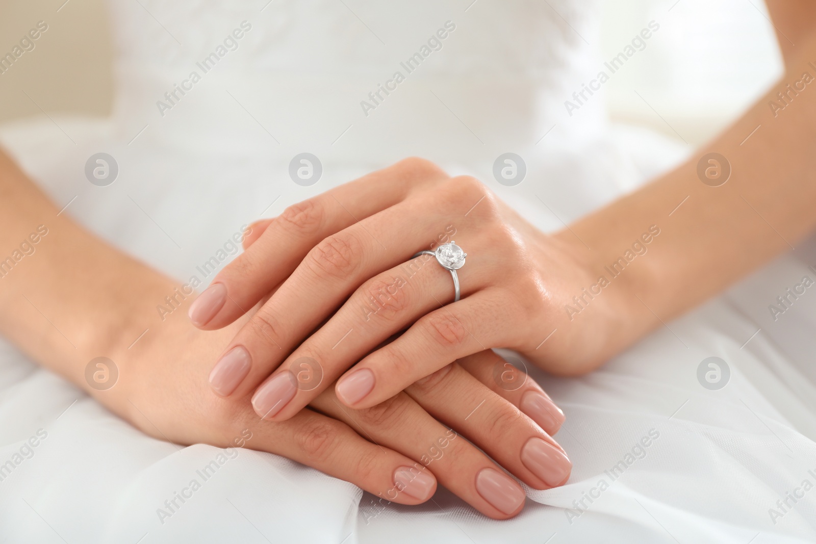 Photo of Young bride wearing beautiful engagement ring, closeup