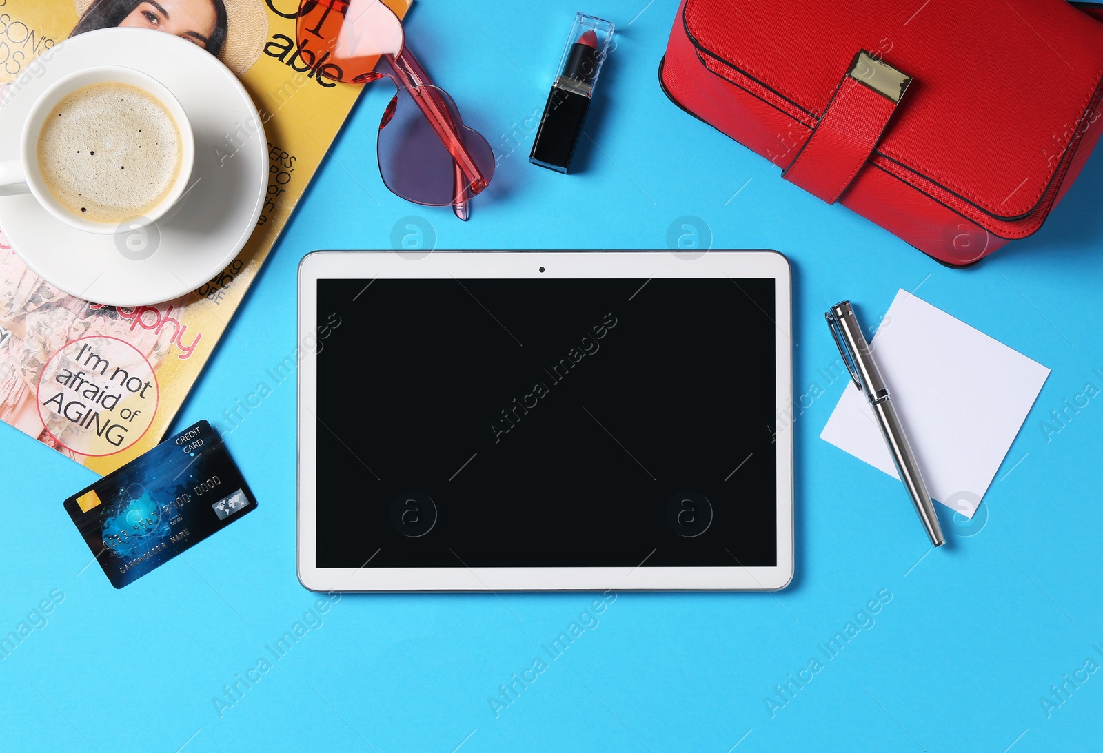 Photo of Online store. Tablet, stationery, credit card, coffee, magazine and accessories on light blue background, flat lay