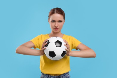 Photo of Fan holding football ball on light blue background