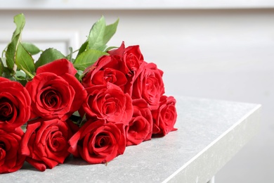 Photo of Beautiful red rose flowers on table indoors