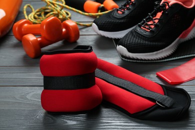 Photo of Red weighting agents and sport equipment on grey wooden table