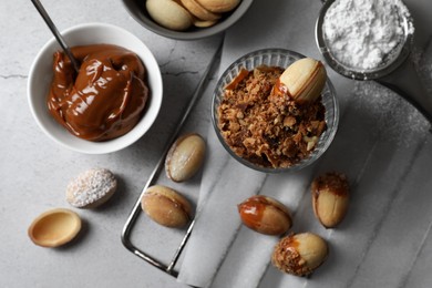 Delicious walnut shaped cookies with condensed milk on grey table, flat lay