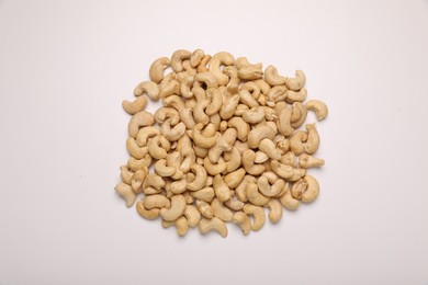 Pile of tasty cashew nuts on white background, top view