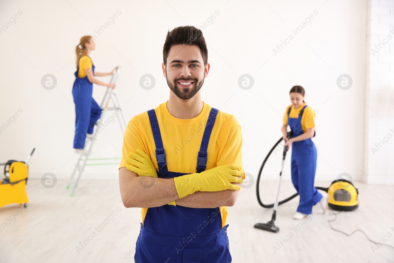 Photo of Professional janitor in uniform indoors. Cleaning service