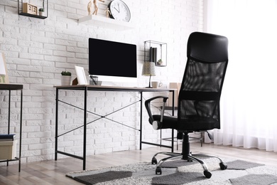 Comfortable chair near desk in modern office interior