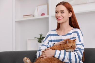Photo of Happy woman with her cute cat at home. Space for text