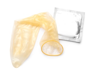 Unrolled condom and package on white background, top view. Safe sex