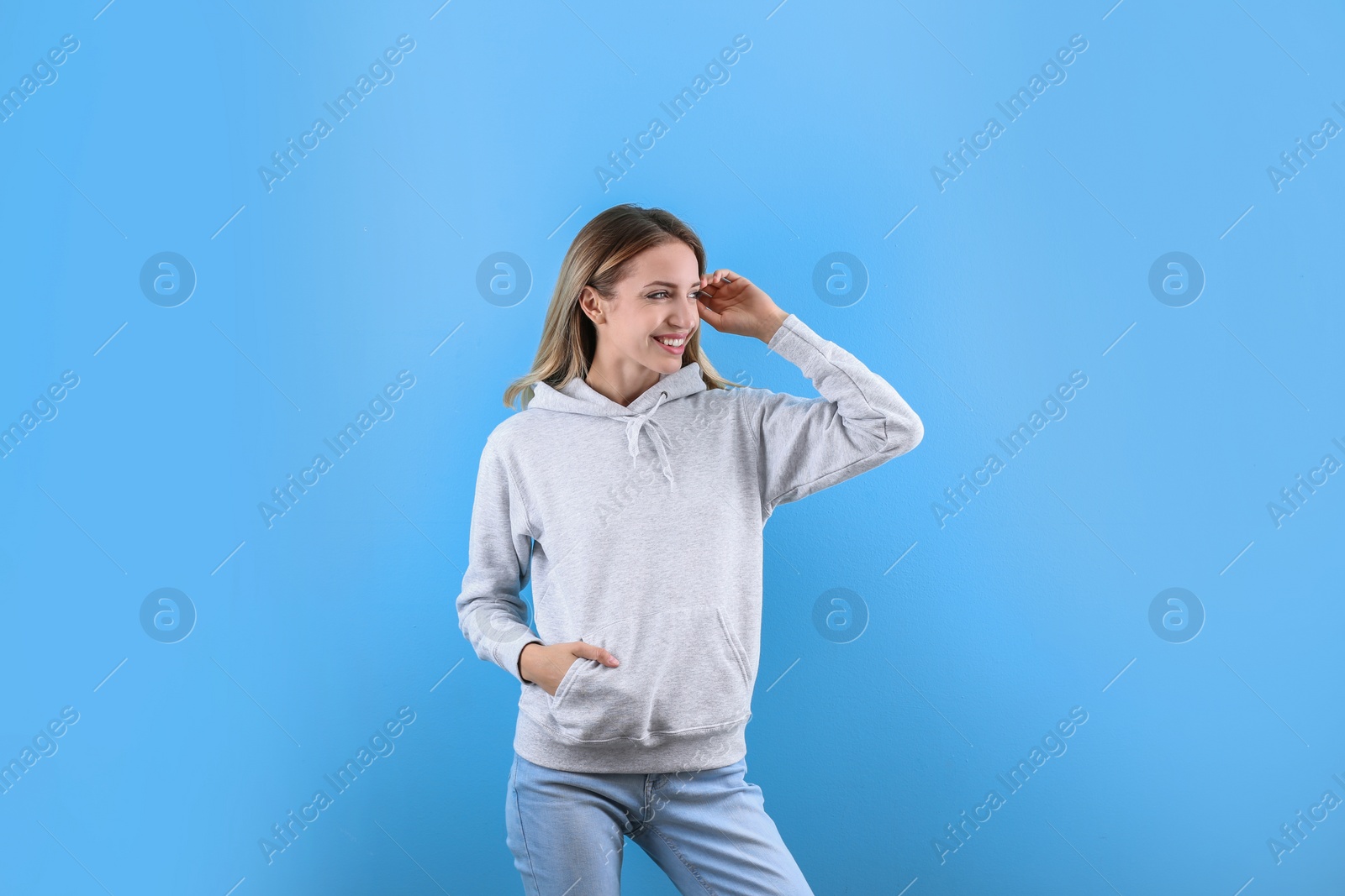 Photo of Portrait of woman in hoodie sweater on color background. Space for design